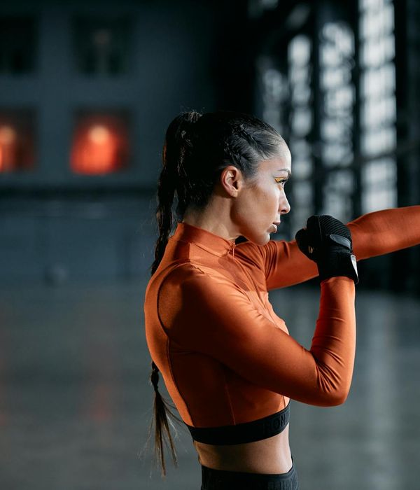 Woman performing a light cardio exercise in a calm, modern studio.
